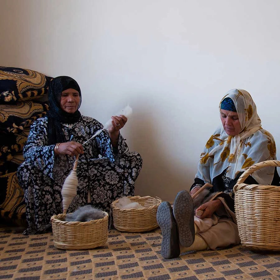 Berber artisans weaving a handmade Moroccan rug.