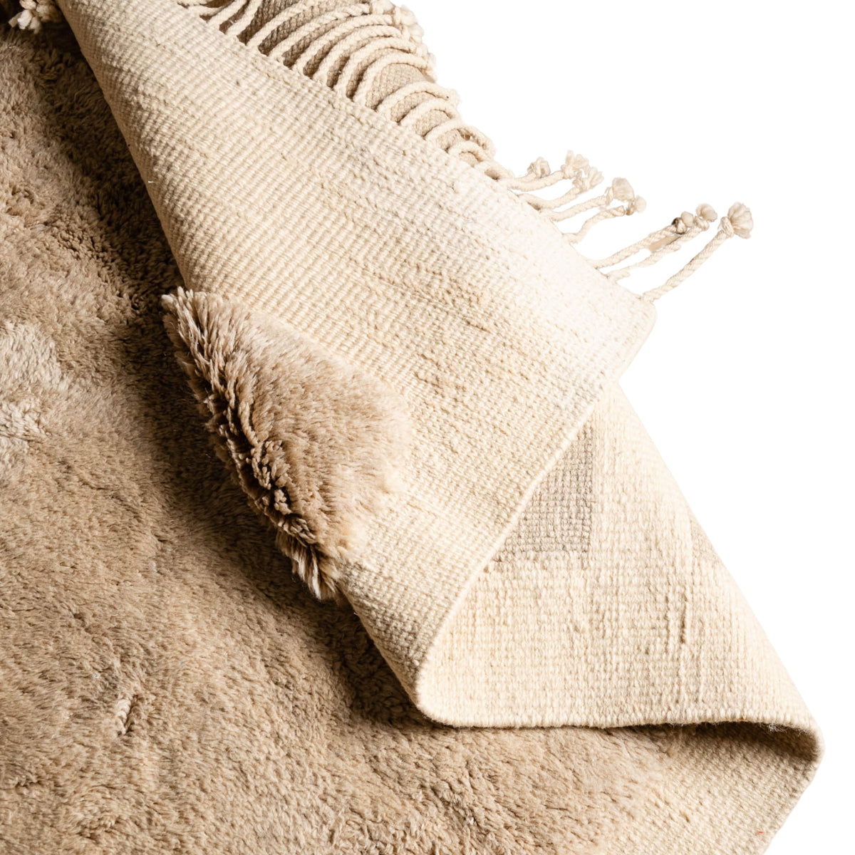 closeup flipped Handmade Moroccan wool rug in camel beige and ivory with abstract block motif and fringe