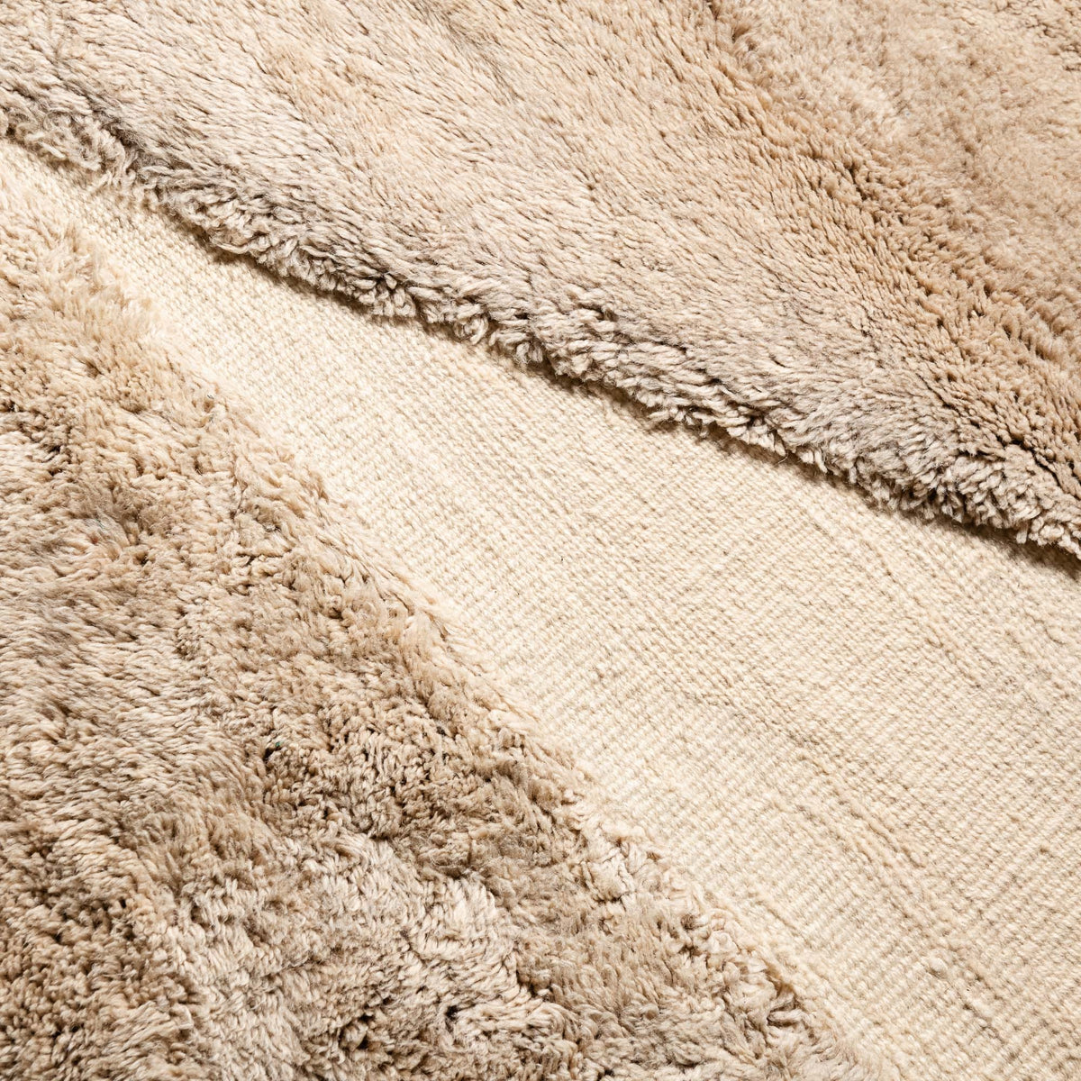 closeup Handmade Moroccan wool rug in camel beige and ivory with abstract block motif and fringe