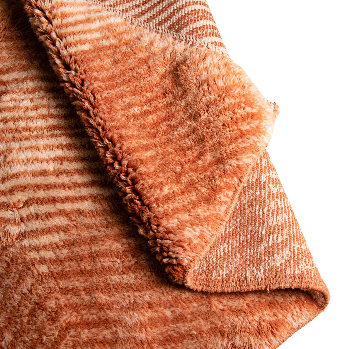 closeup flipped Handmade Moroccan wool rug in coral orange and ivory with radiating chevron stripes