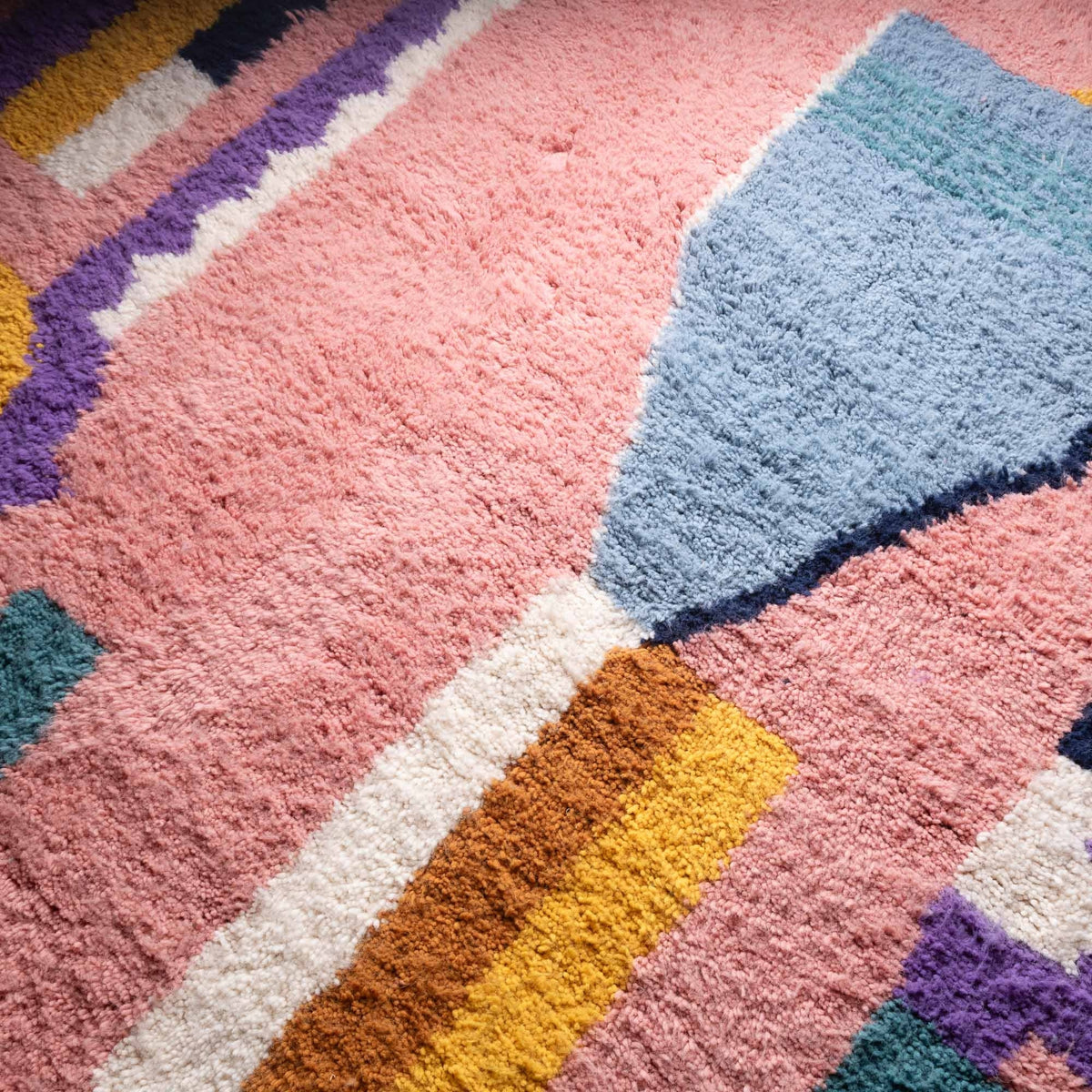 Closeup Handmade Moroccan wool rug blush pink with carved multicolor abstract blocks