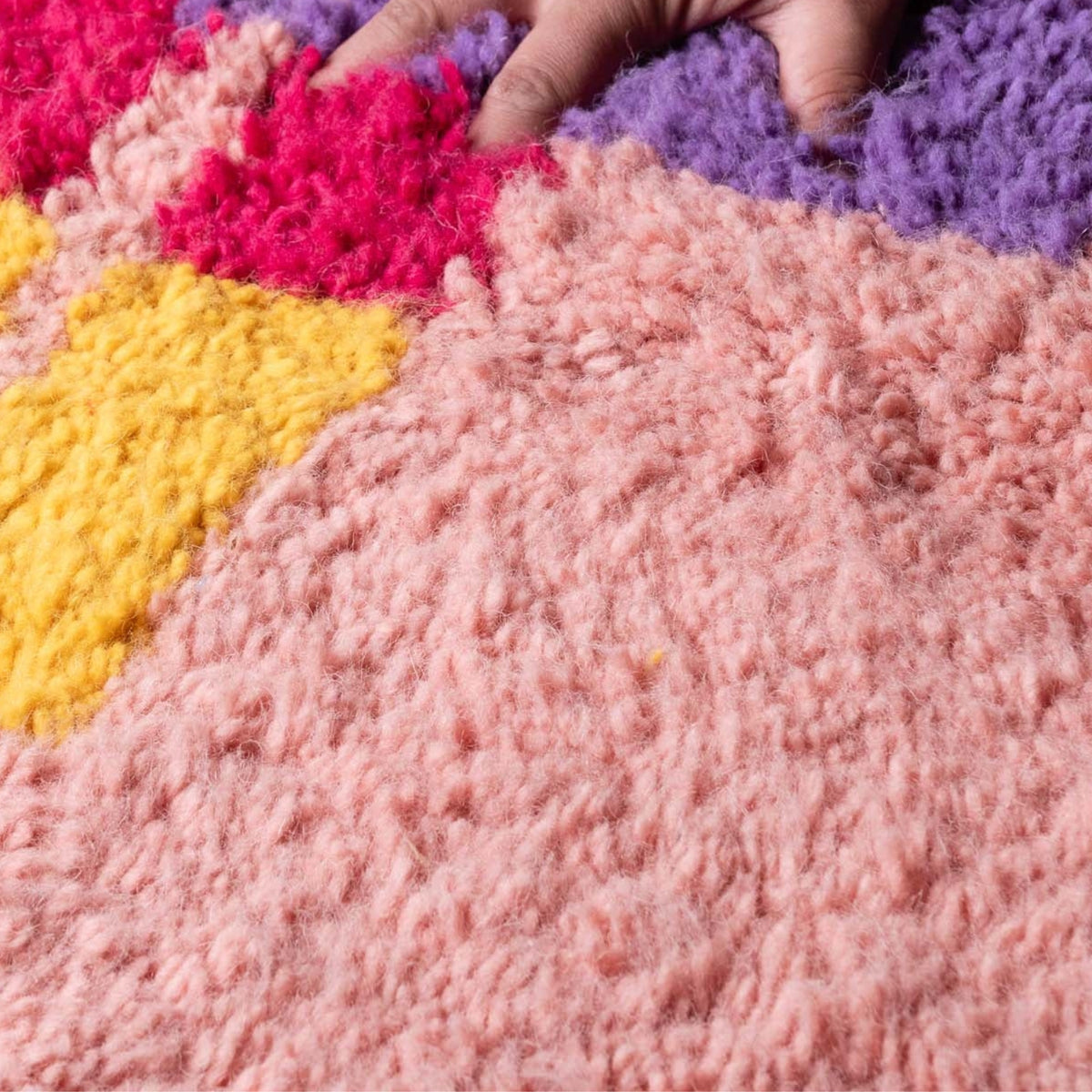 Closeup Handmade Moroccan wool rug blush pink with carved multicolor abstract blocks