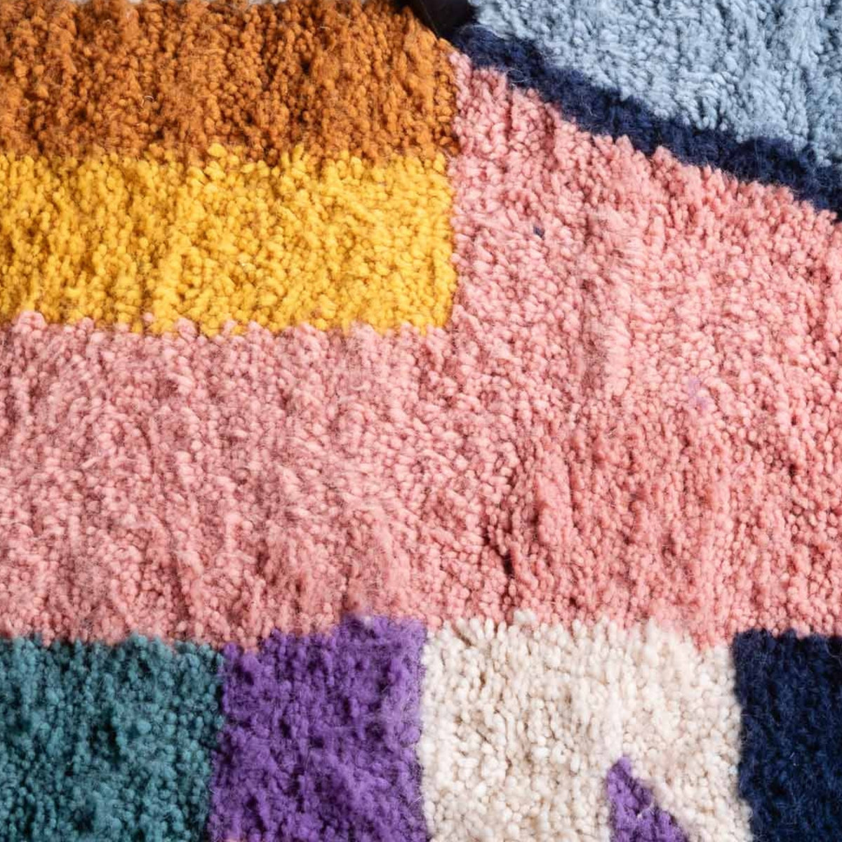 Closeup Handmade Moroccan wool rug blush pink with carved multicolor abstract blocks