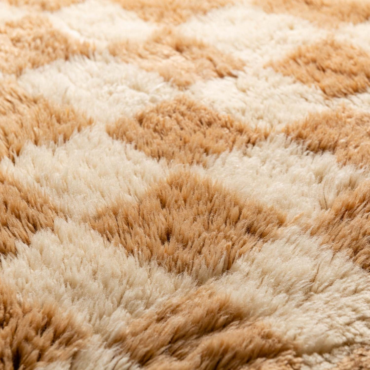 Closeup Handmade Moroccan wool rug gold with carved ivory checkerboard relief