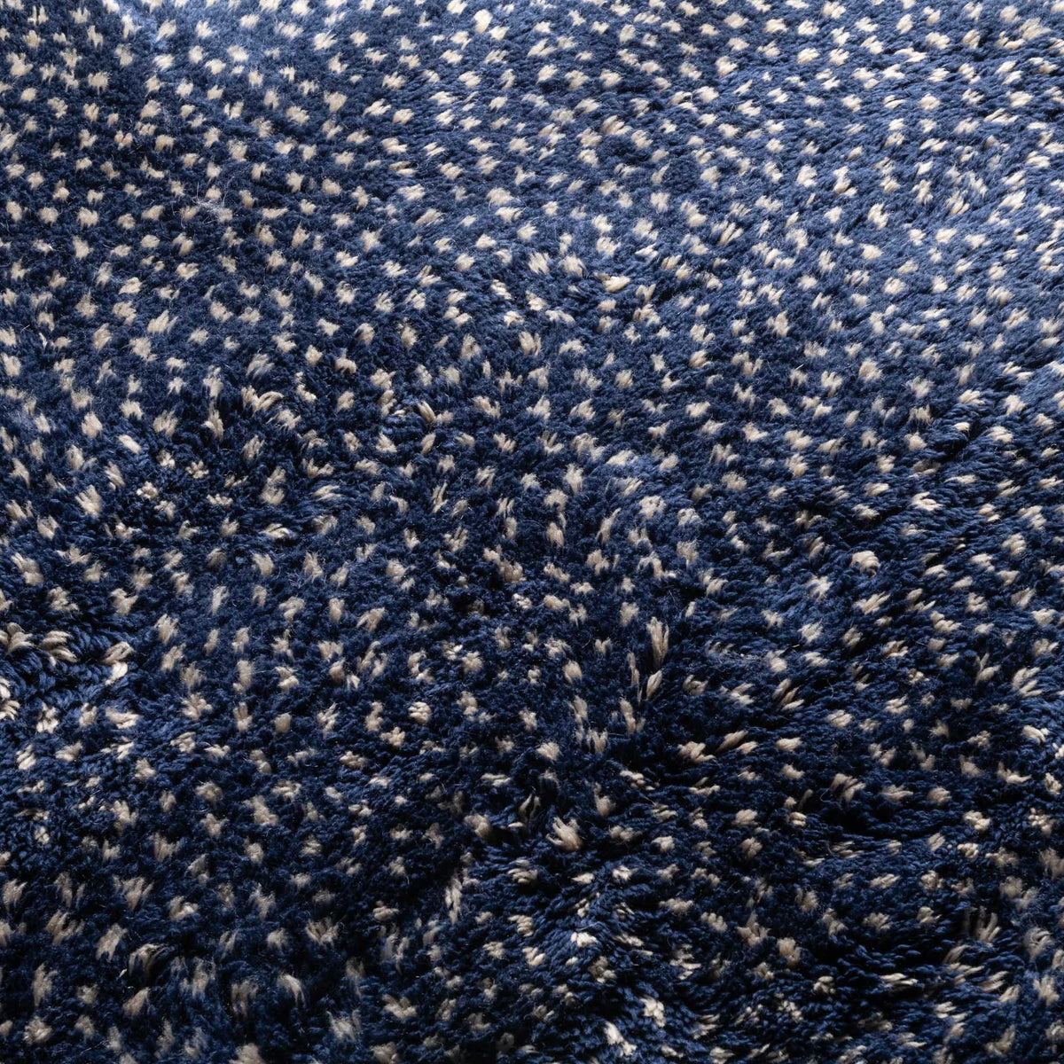 Closeup Handmade Moroccan wool rug indigo with carved ivory dot constellation pattern