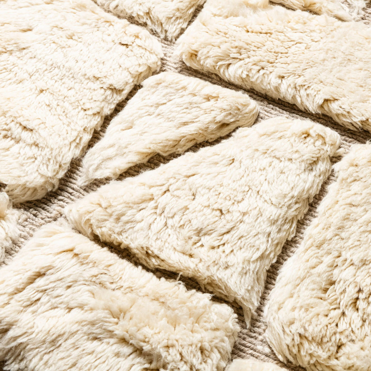 Close-up Handmade Moroccan wool rug ivory cream with carved geometric relief mosaic pattern and fringe