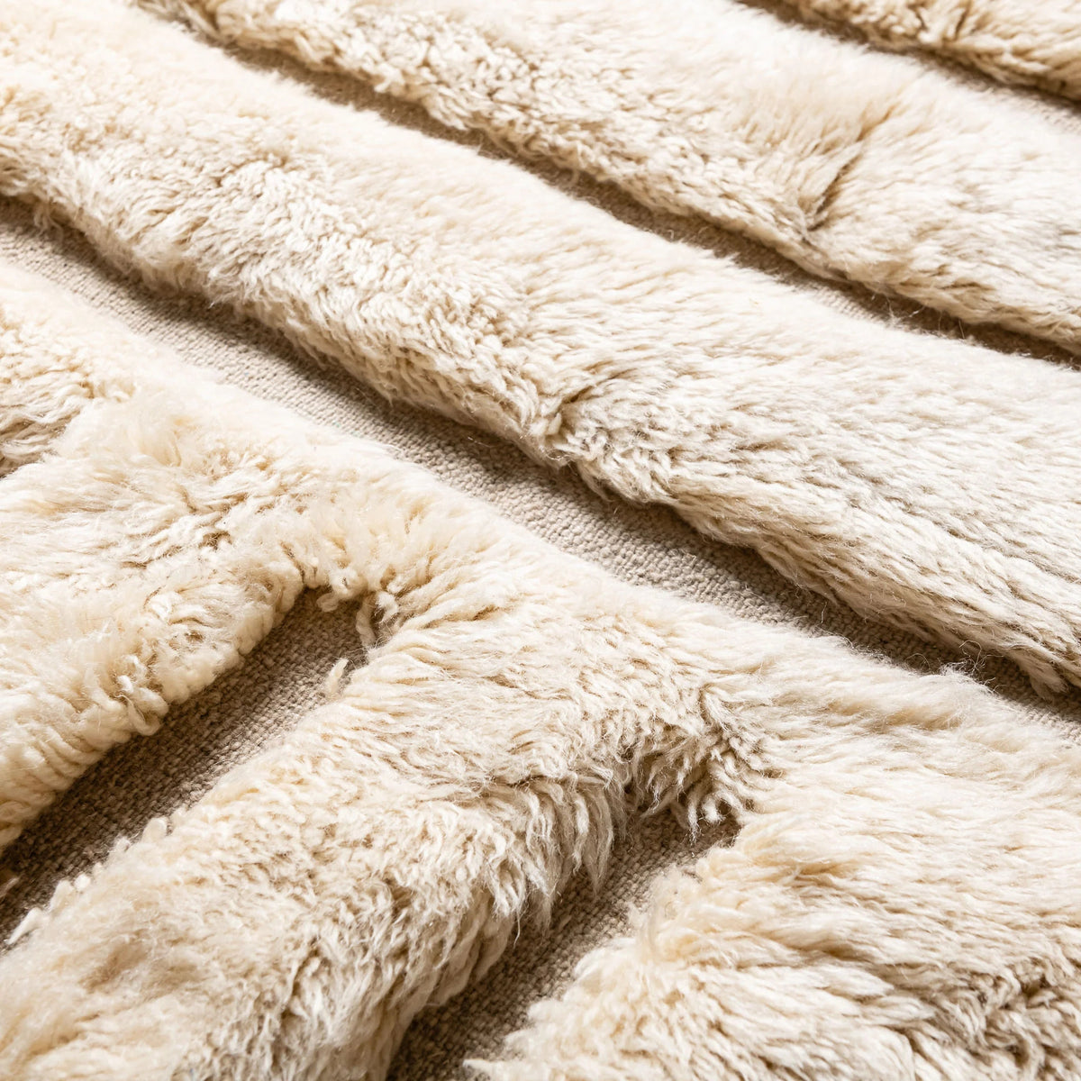 close up Handmade Moroccan wool rug in ivory cream with carved sand-tone labyrinth relief and fringe