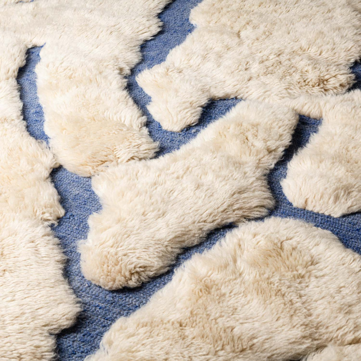 closeup Handmade Moroccan wool rug ivory with carved indigo freeform vertical lines