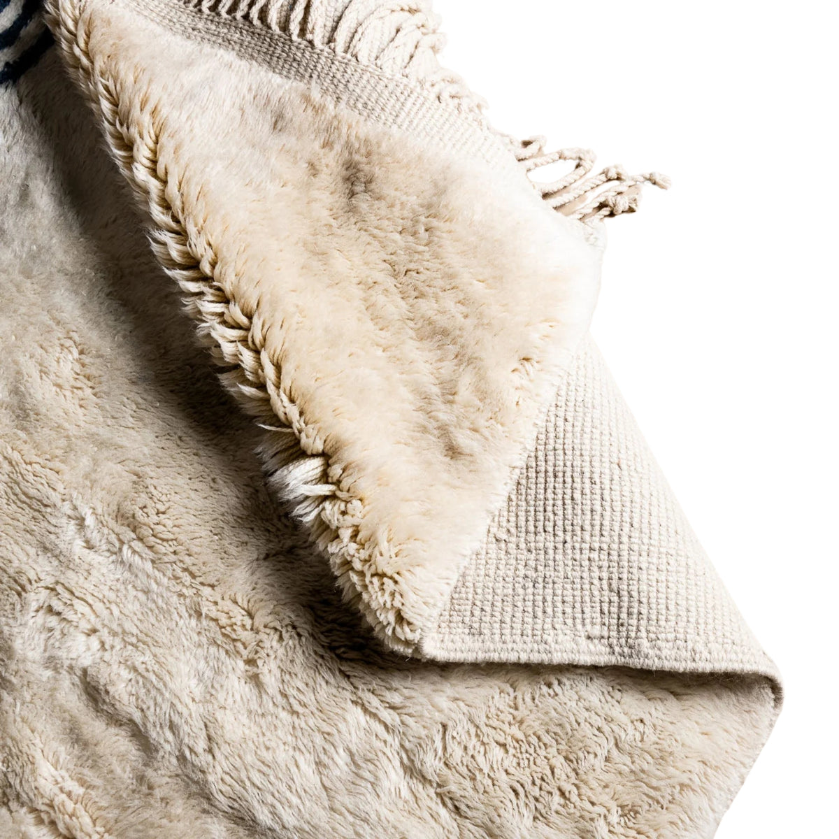 flipped Handmade Moroccan wool rug in cream with navy parallel line chords and fringe