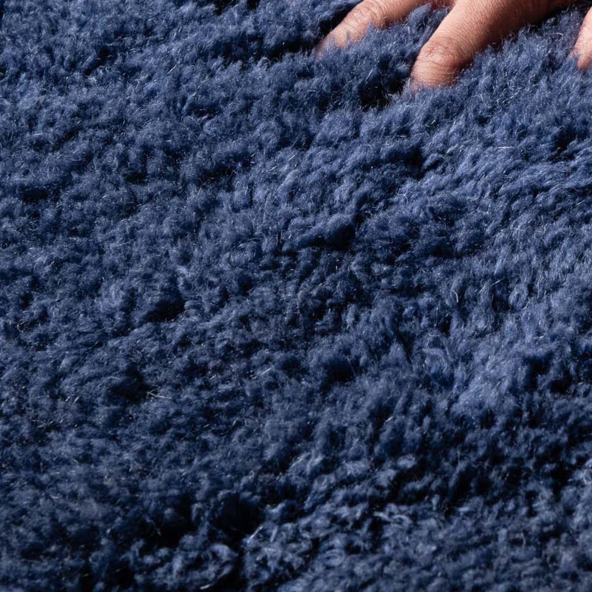 closeup Handmade Moroccan wool rug in deep navy with carved geometric relief lines