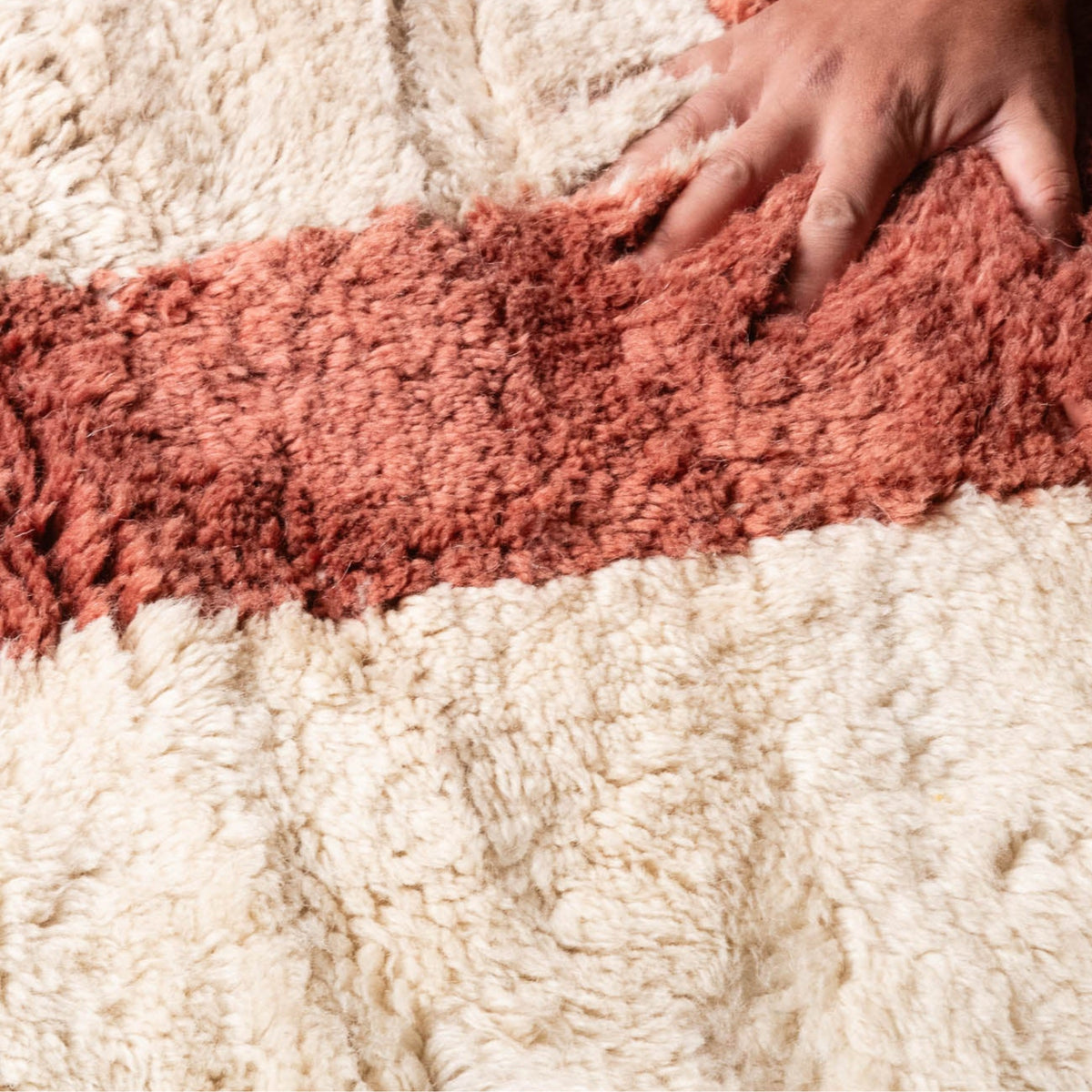 closseup texture Handmade Moroccan wool rug in cream with rust-red, charcoal, gray, and mustard abstract block design