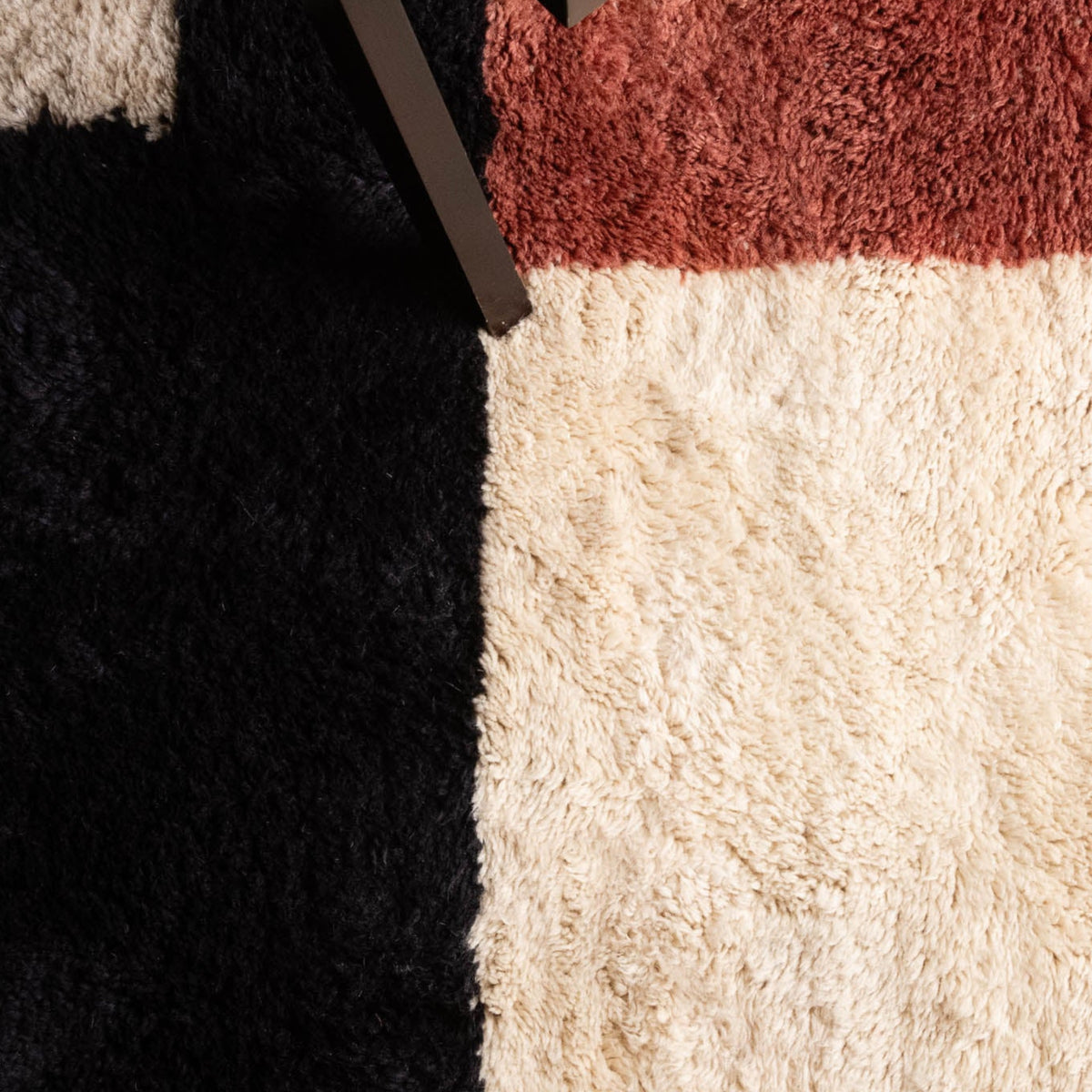 closeup Handmade Moroccan wool rug in cream with rust-red, charcoal, gray, and mustard abstract block design