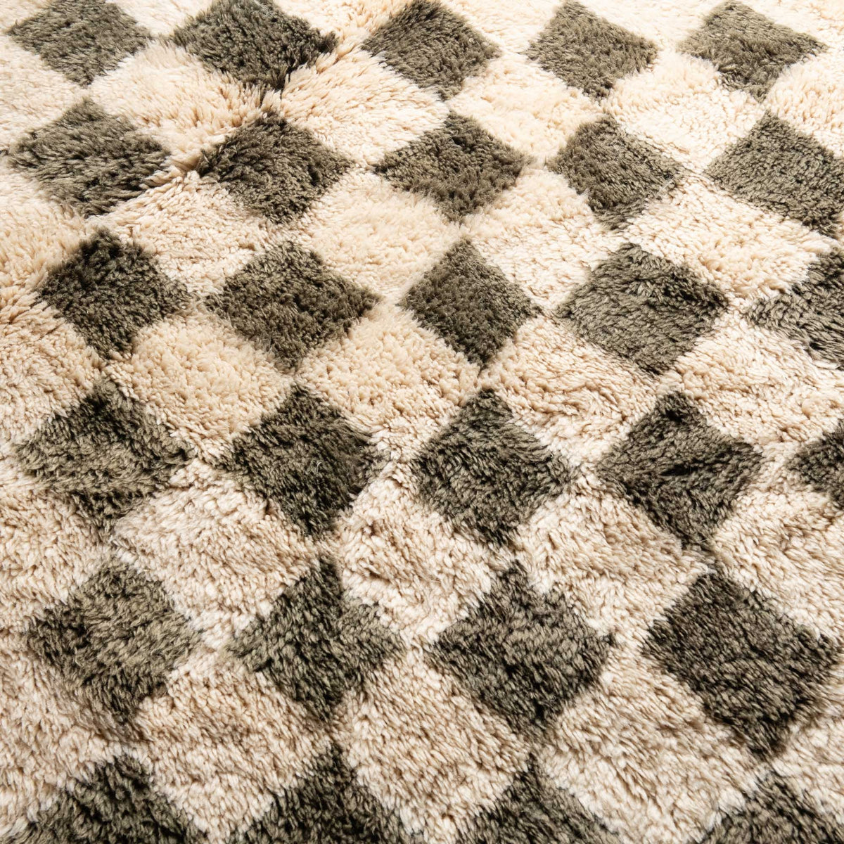 Closeup Handmade Moroccan wool rug sage green with carved ivory checkerboard relief